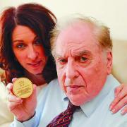 Henry Wermuth with daughter Ilana Metzger holding the medal he was awarded by the German government in 1995 for his assassination attempt on Hitler