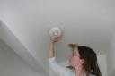 Sarah Brown, safety advisor with Harrow Association of Disabled People, installs a smoke alarm