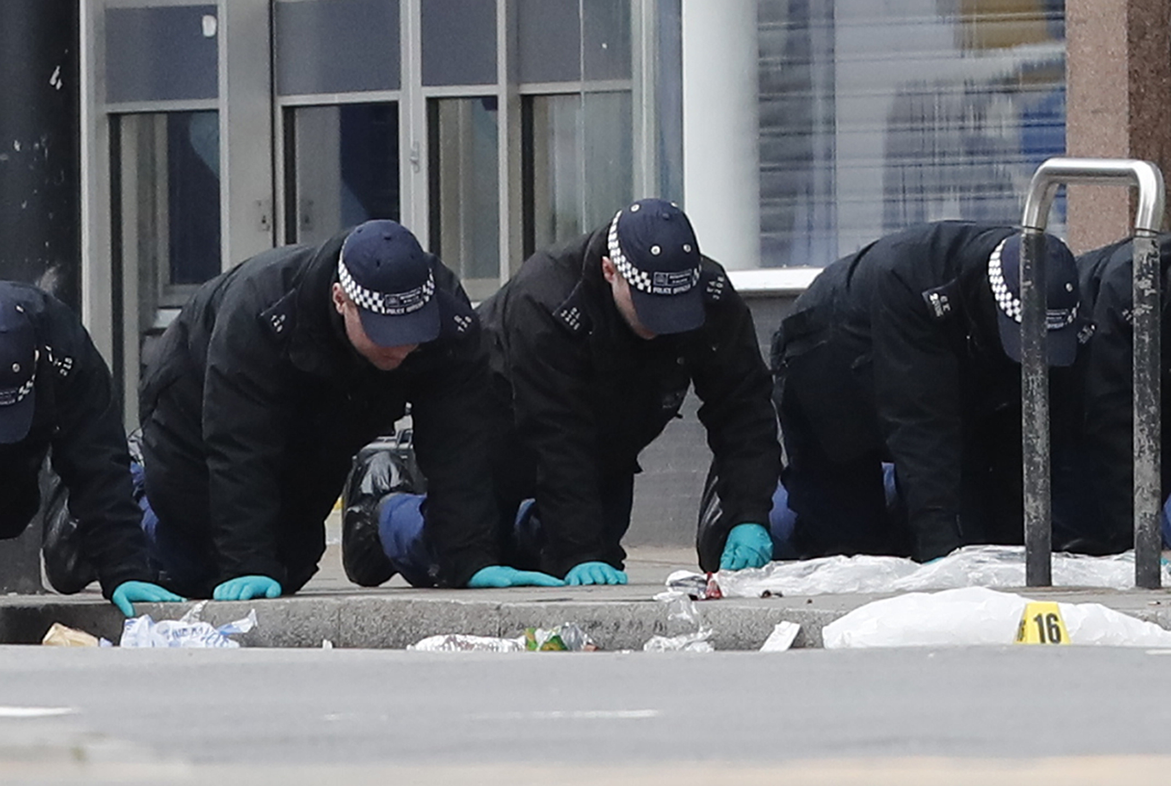 Police officers conducting a finger tip search at the scene (Photo: PA)