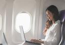 A woman on a laptop on a plane. Credit: EFR Travel Group