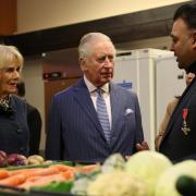 King Charles III and the Queen Consort speak with Chief Executive and founder of London's Community Kitchen Taz Khan