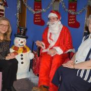 Centre Manager, Izabela Honowska (left), telling Santa about her Christmas wish list while volunteer Margaret McDonald looks on