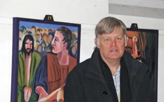 Jonathan Hutchins with his paintings in All Saints' Church in Harrow